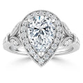Pear-shaped diamond ring with a halo of small diamonds and intricate accents on a polished silver band.