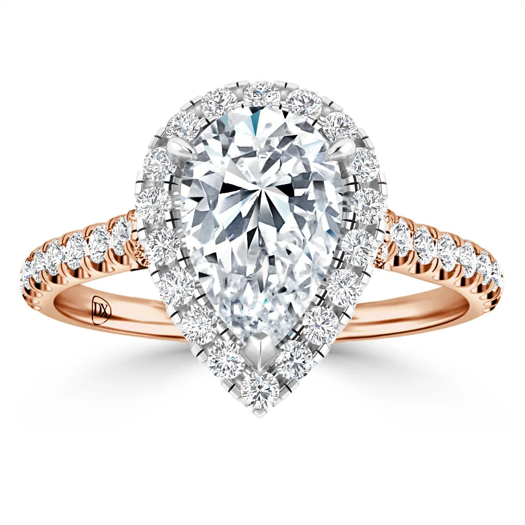 Pear-shaped diamond ring with a double halo and pave diamonds on a rose gold band, viewed from the front.