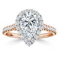 Pear-shaped diamond ring with a double halo and pave diamonds on a rose gold band, viewed from the front.