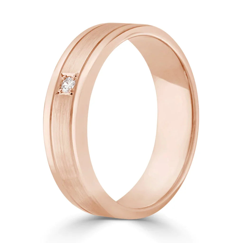 A rose gold band with a brushed finish and a small round diamond set flush into the surface.