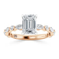 Emerald-cut diamond ring with marquise side stones on a rose gold band, viewed from the front.