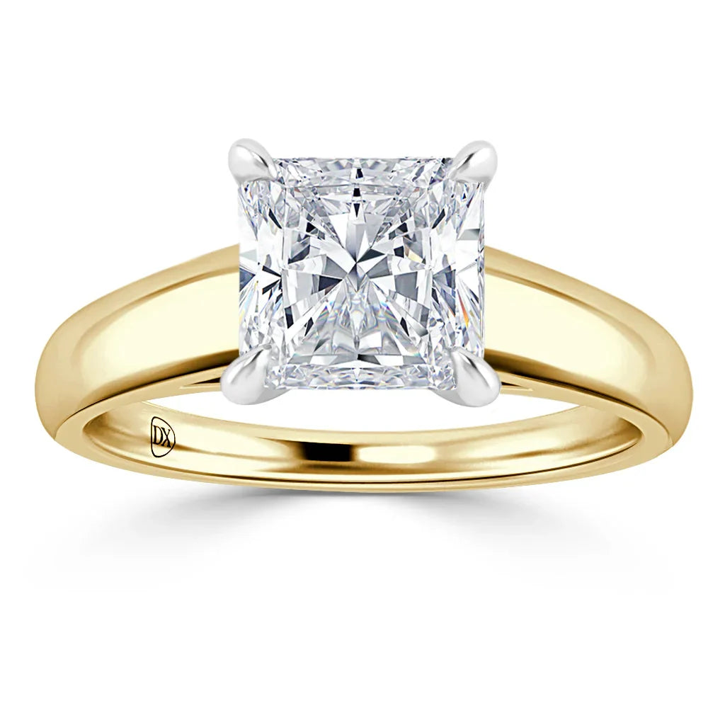 Gold band ring with a large, square-cut diamond solitaire set in a four-prong, white gold setting.