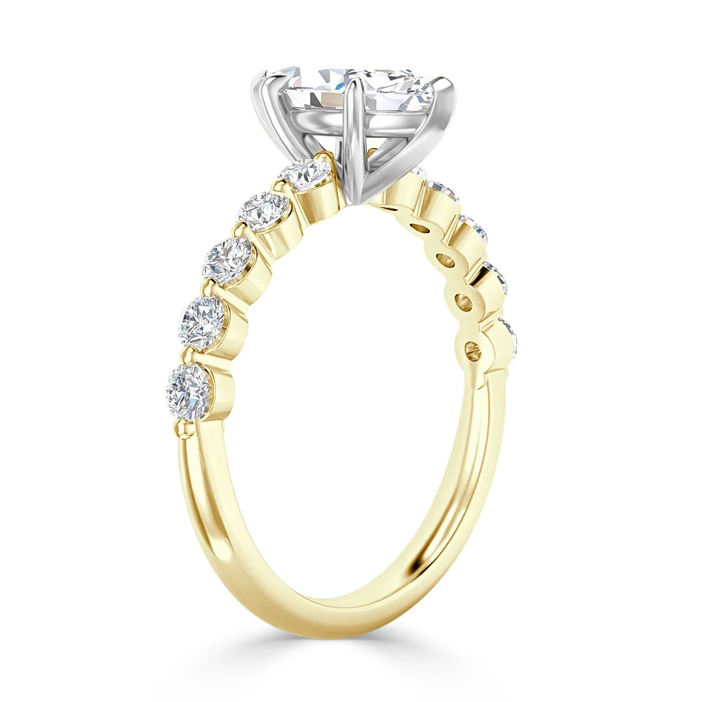 A gold ring with round diamonds on the band and a large solitaire diamond set in a white gold prong setting.