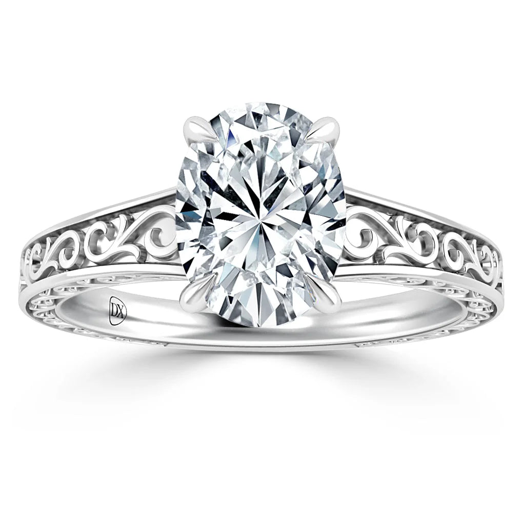 Silver ring with an oval diamond and intricate filigree detailing on the band, shown on a white background.