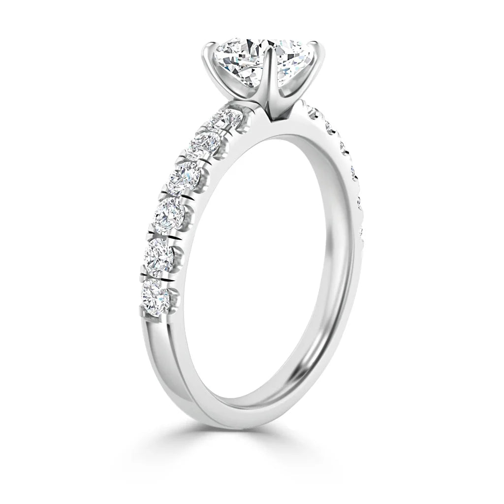 White gold ring with round diamonds on the band and a large center solitaire diamond in a prong setting.
