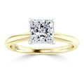 A gold ring with a large, square-cut diamond solitaire set in a four-prong white gold setting.