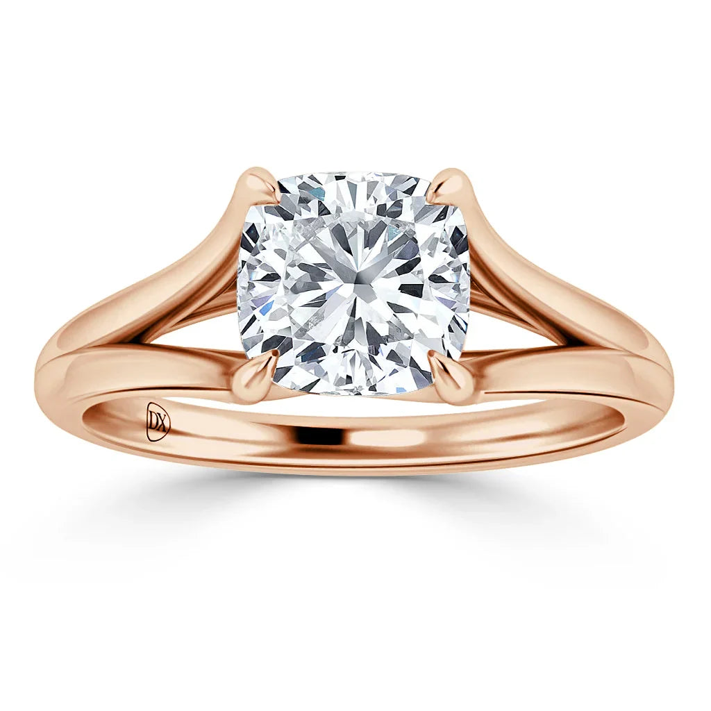 Rose gold ring with a cushion-cut diamond solitaire held by four prongs and a split shank band.