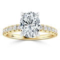 Yellow gold ring with an oval diamond center and round diamonds set along the band, shown on white background.