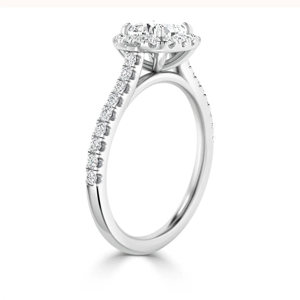 A white gold ring with a round diamond center stone and a halo setting, featuring diamonds on the band.