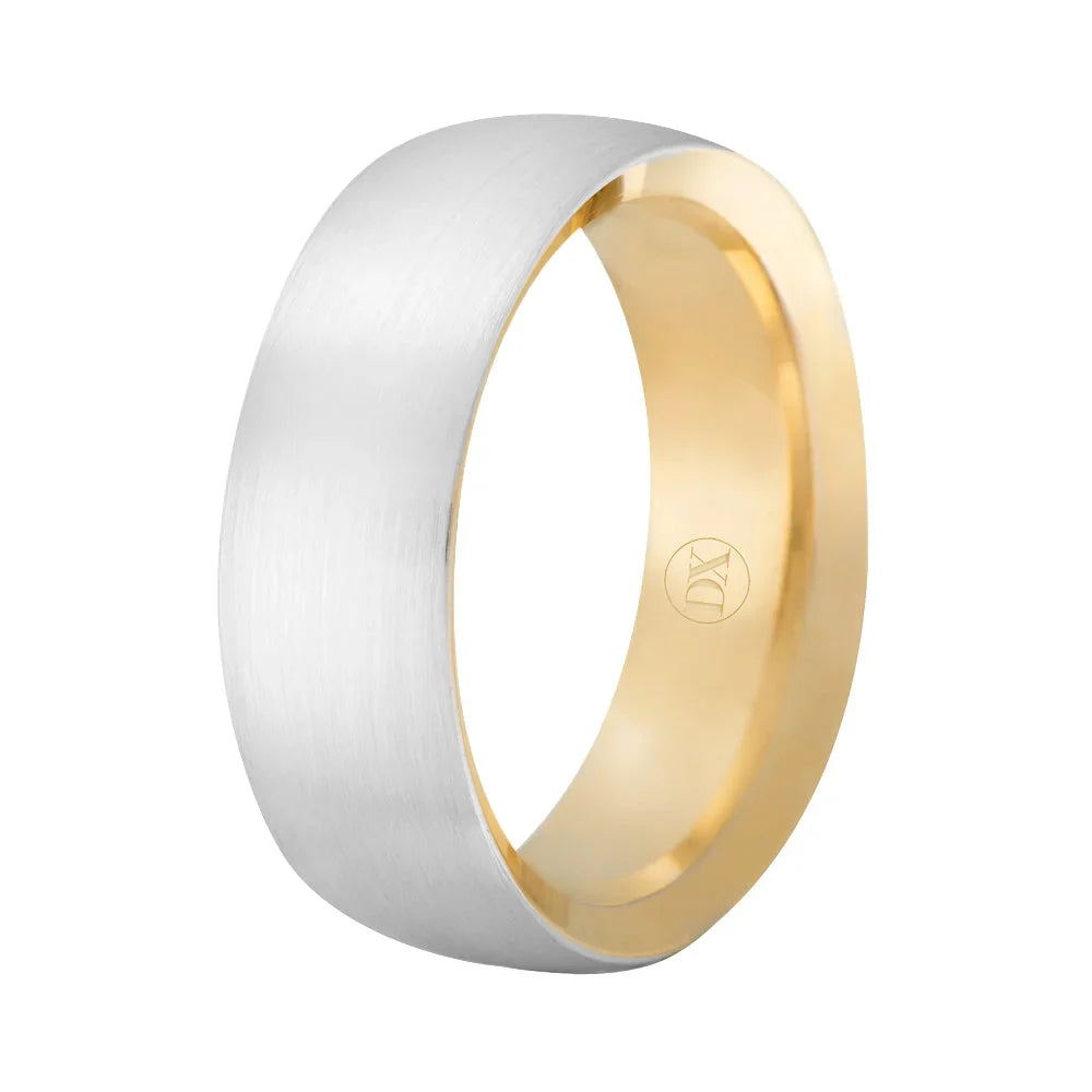A gold ring with a brushed silver outer band and a shiny gold interior, featuring a small engraved logo inside.