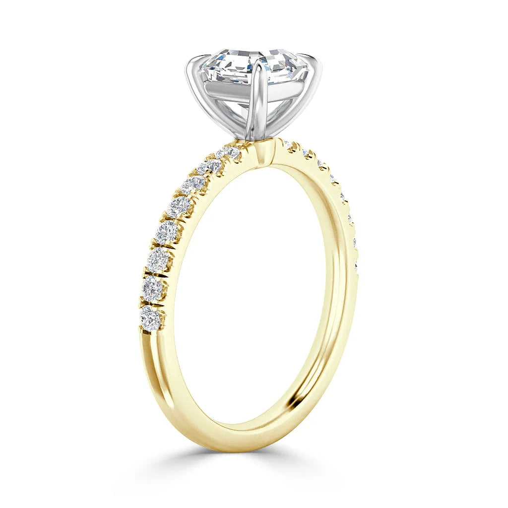A gold band ring with small diamonds on the side and a large round diamond in a silver prong setting.