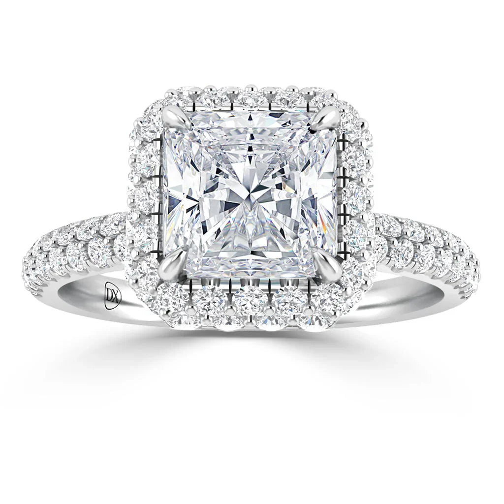 Square-cut diamond ring with double halo of smaller diamonds on a diamond-encrusted white gold band.