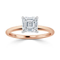 A rose gold band with an asscher-cut diamond solitaire set in a white gold prong setting.
