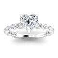 A silver ring with a heart-shaped diamond center and marquise-shaped side diamonds on the band.