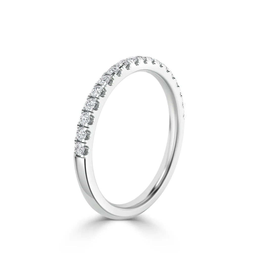 Slim white gold ring with a row of small round diamonds set along the top half, shown on a white background.