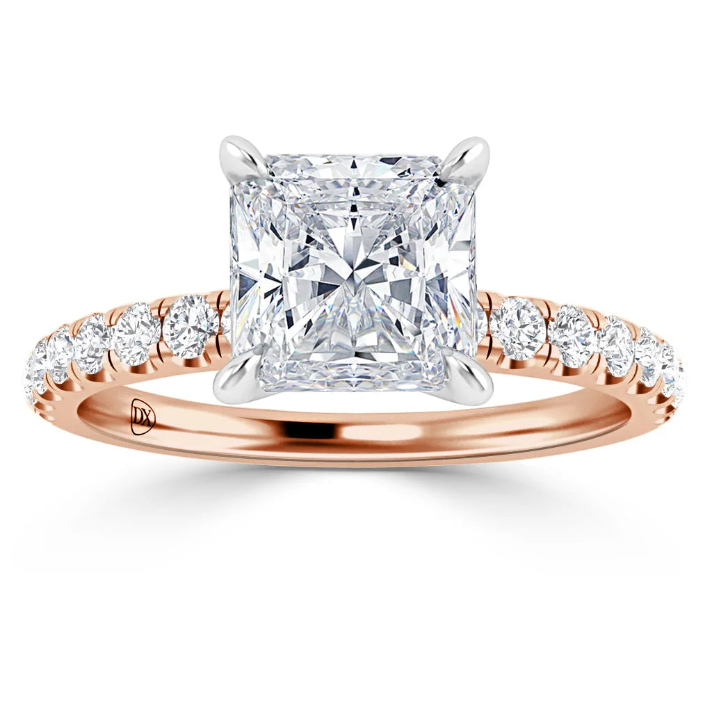 A rose gold ring with a large square diamond and smaller diamonds set along the band.