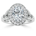 Oval diamond ring with double halo, intricate side detailing, and milgrain accents on a white gold band.