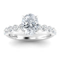 Oval-cut diamond ring with a pavé diamond band on a polished white metal setting.