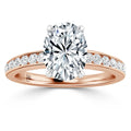 Rose gold ring with an oval diamond center stone and smaller diamonds set along the band.