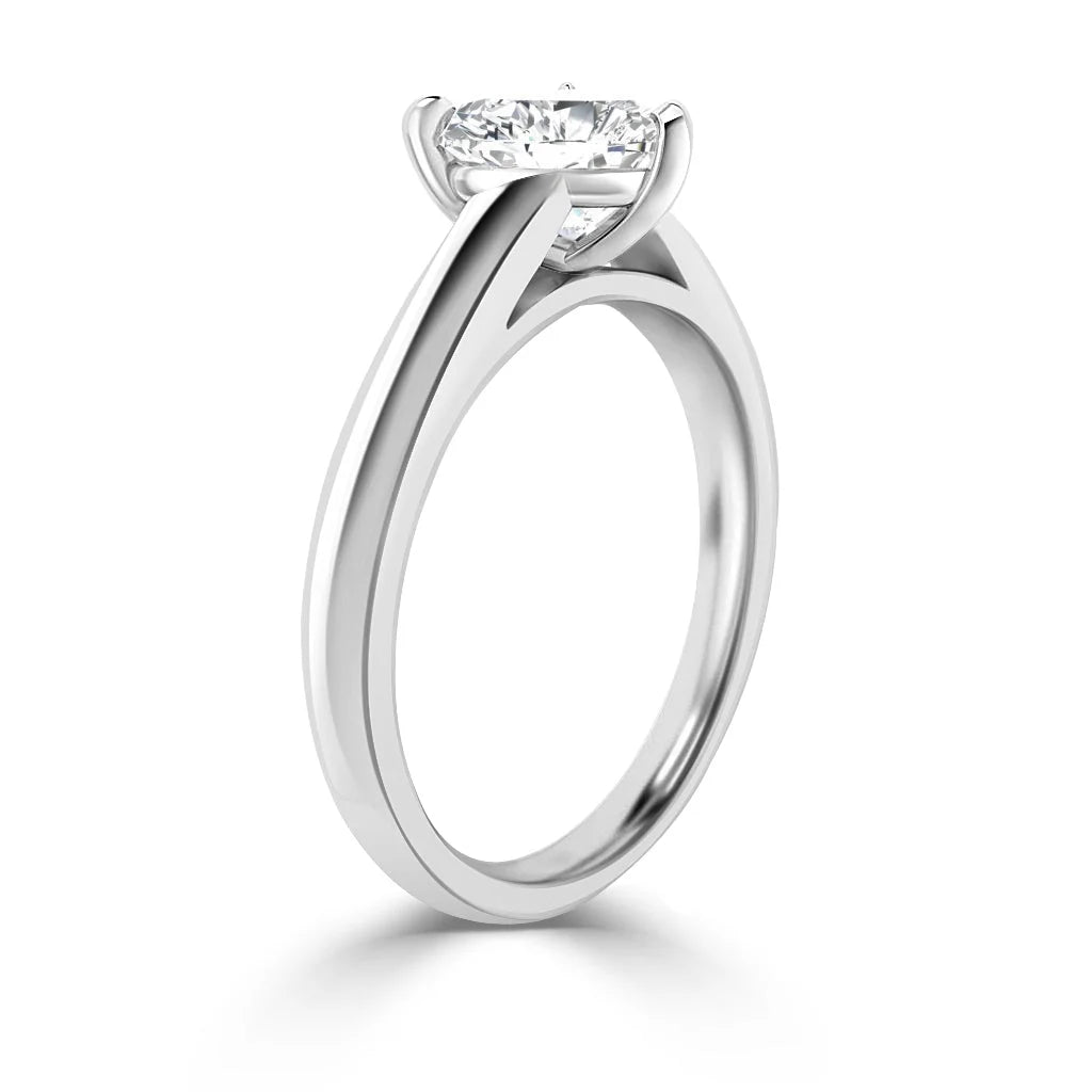 A solitaire diamond engagement ring with a sleek, polished white gold band in a side view.