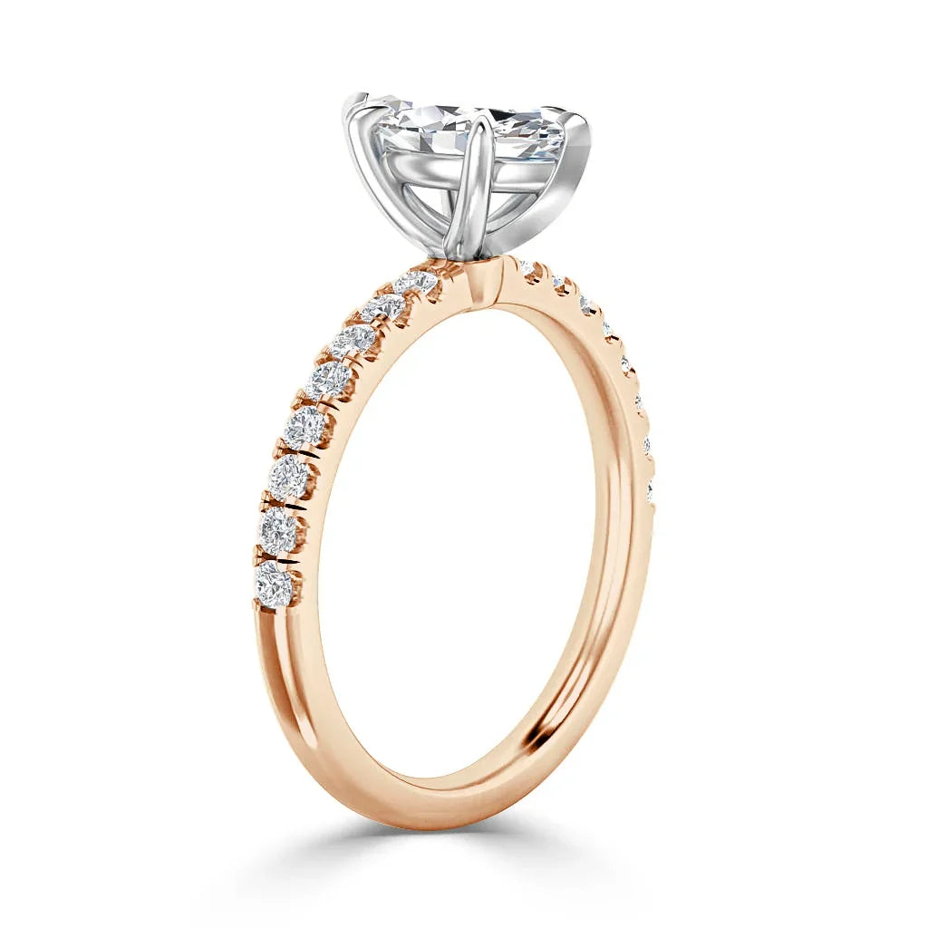 Rose gold ring with small diamonds on the band and a large round solitaire diamond in a silver prong setting.