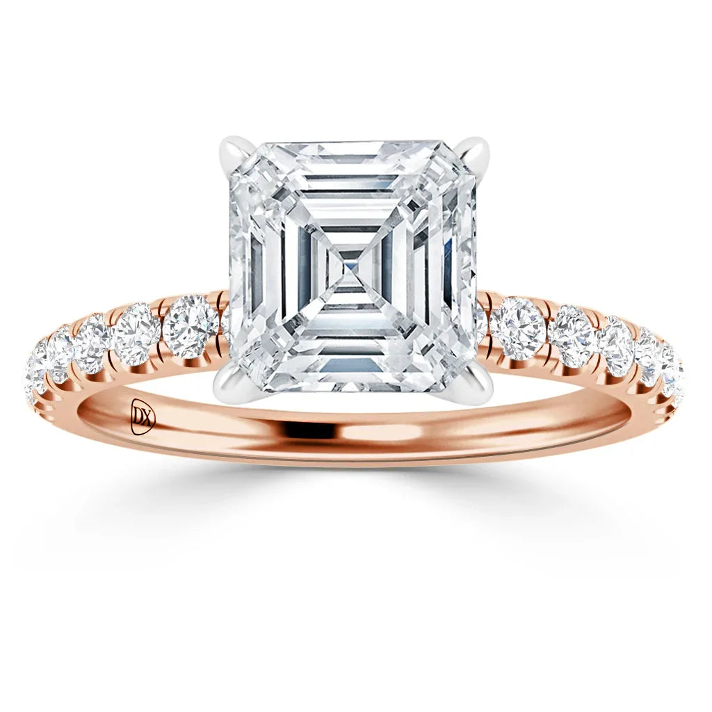 A rose gold ring with an Asscher-cut diamond center and round diamonds on the band, on a white background.