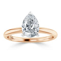 A rose gold ring with a pear-shaped diamond solitaire set in a simple, polished band.