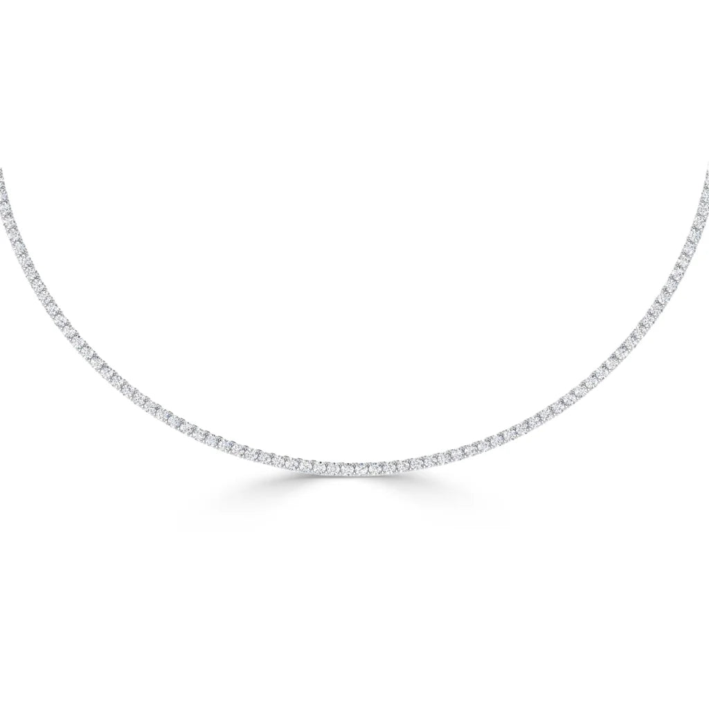 A delicate tennis necklace with a continuous row of small, sparkling diamonds set in white metal.