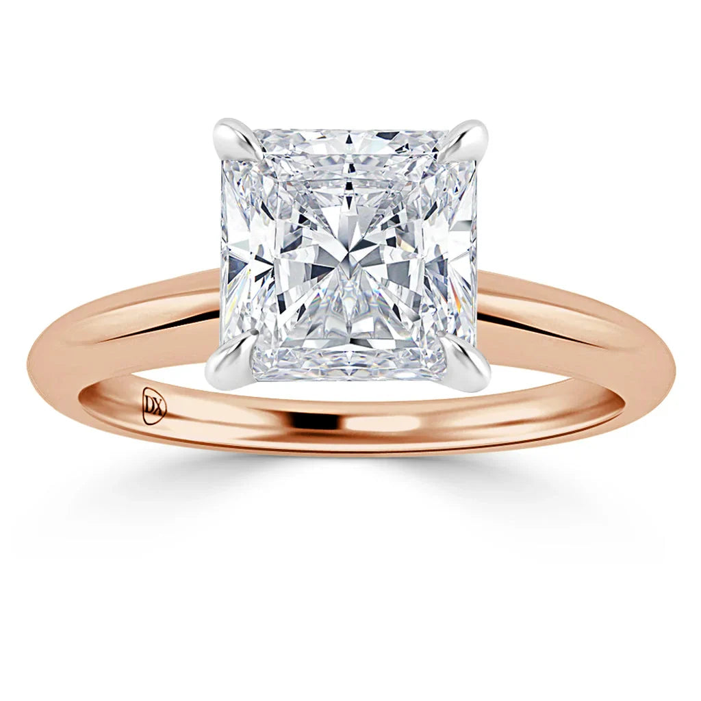 A rose gold ring with a large, square-cut diamond set in a four-prong white gold setting.