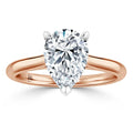 A pear-shaped diamond solitaire on a polished rose gold band, shown against a white background.