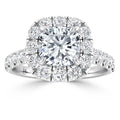 Cushion-cut diamond ring with a double halo of round diamonds set in a white metal band.
