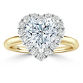 Heart-shaped diamond ring with a yellow gold band and a halo of small round diamonds around the center stone.