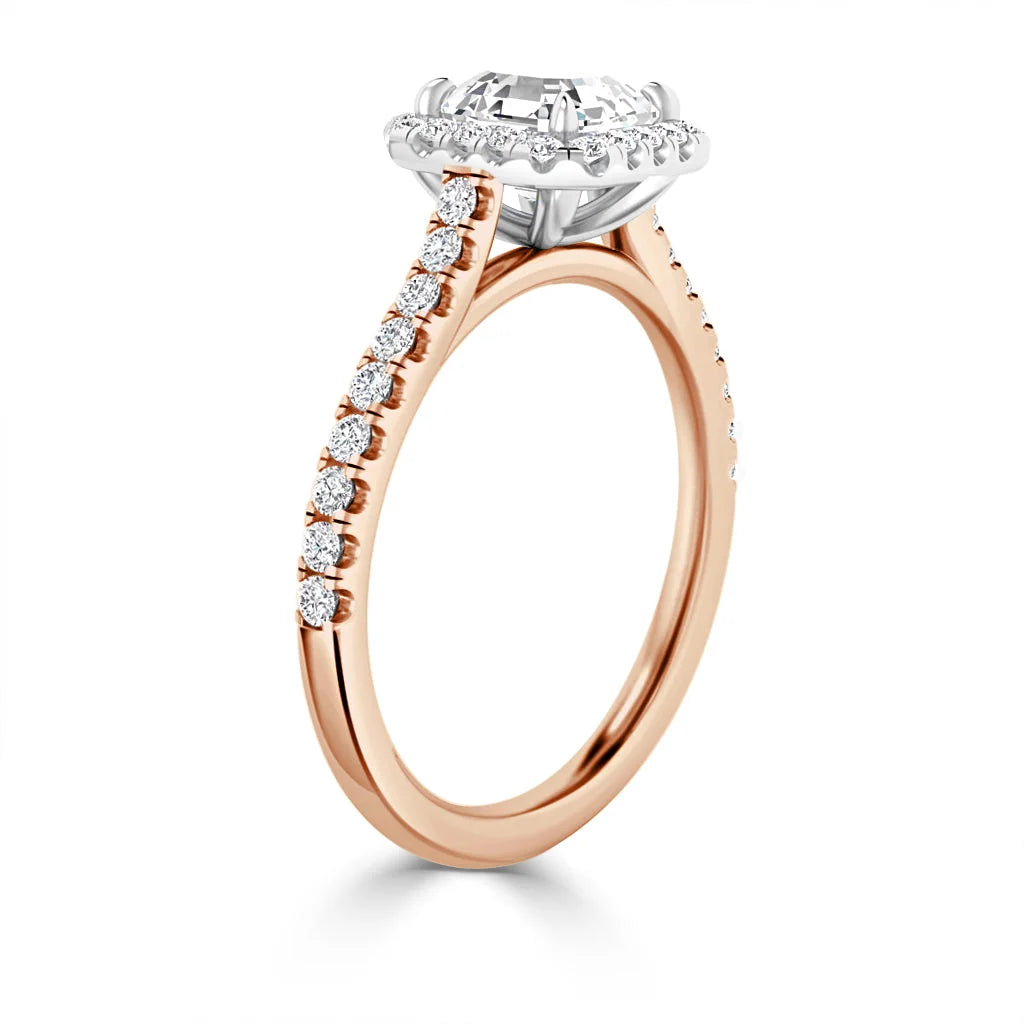 Rose gold ring with a diamond halo setting and pavé diamonds on the band, side view on white background.