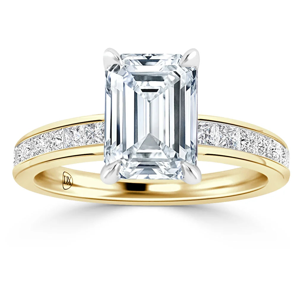 Emerald-cut diamond ring with yellow gold band, accented by small round diamonds along the band.