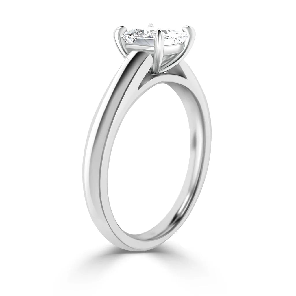 Side view of a solitaire diamond ring with a sleek, polished white gold band and four-prong setting.
