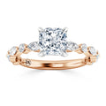Rose gold ring with a cushion-cut center diamond and marquise diamond accents on the band.