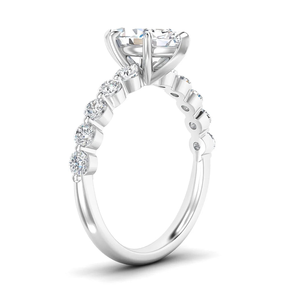 A silver ring with round diamonds along the band and a large solitaire diamond set in a prong setting.