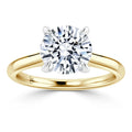 A gold solitaire ring with a large round diamond in a four-prong setting, shown on a white background.