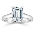 A silver ring with a large emerald-cut diamond held by four prongs, shown on a white background.