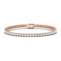 A rose gold tennis bracelet with a row of round, sparkling white diamonds and a secure clasp.