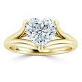 A gold ring with a heart-shaped diamond solitaire and a split shank band, shown on a white background.