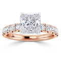 A rose gold ring with a large princess-cut diamond and round diamonds set along the band.