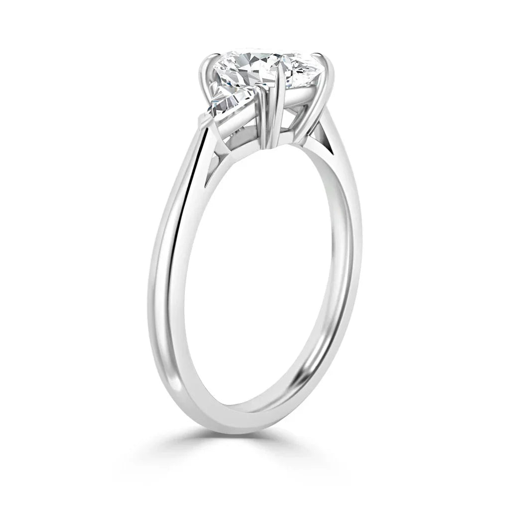 A silver engagement ring with a round, prong-set diamond solitaire on a slender band, shown from the side.