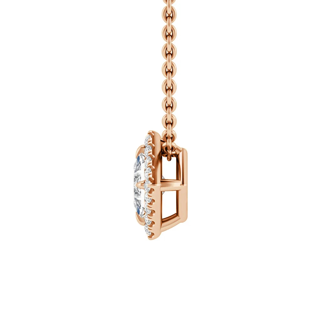 Side view of a rose gold necklace with a round, clear gemstone pendant set in a prong setting against white.