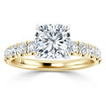 A gold ring with a cushion-cut center diamond and round diamonds set along the band.