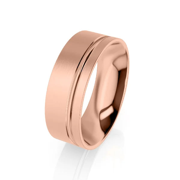 A rose gold wedding band with a brushed finish and a single polished groove near one edge.