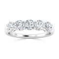 A white gold ring set with five round, sparkling diamonds in a row on a polished band.