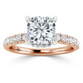 Rose gold ring with a large cushion-cut diamond center and smaller diamonds along the band.
