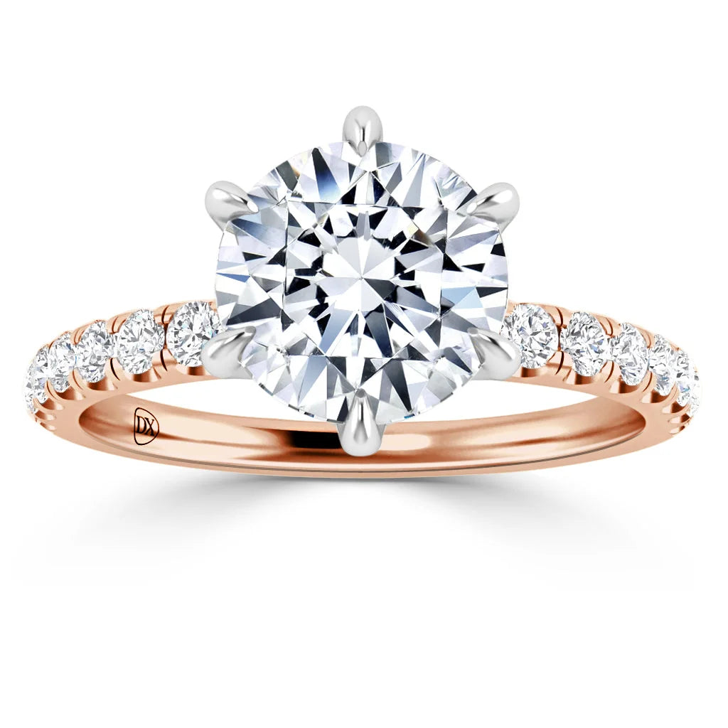 Rose gold ring with a large round diamond center and smaller diamonds along the band, prong setting.