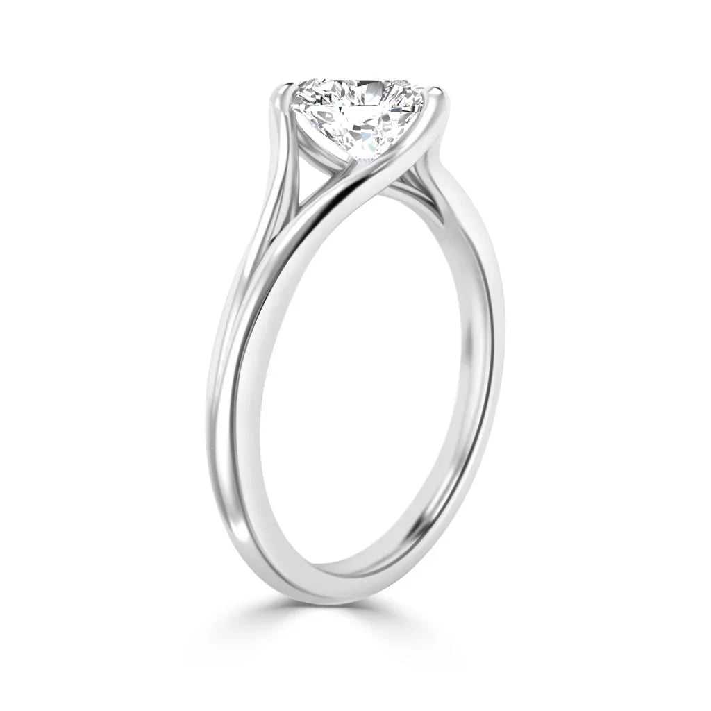 A solitaire diamond ring with a twisted white gold band, shown on a white background.